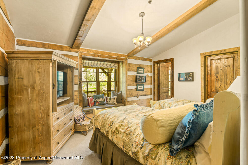 26 Altamira Ranch Road Basalt, CO 81621 - Photo 20 of 40 a spacious bedroom with a bed and a chandelier