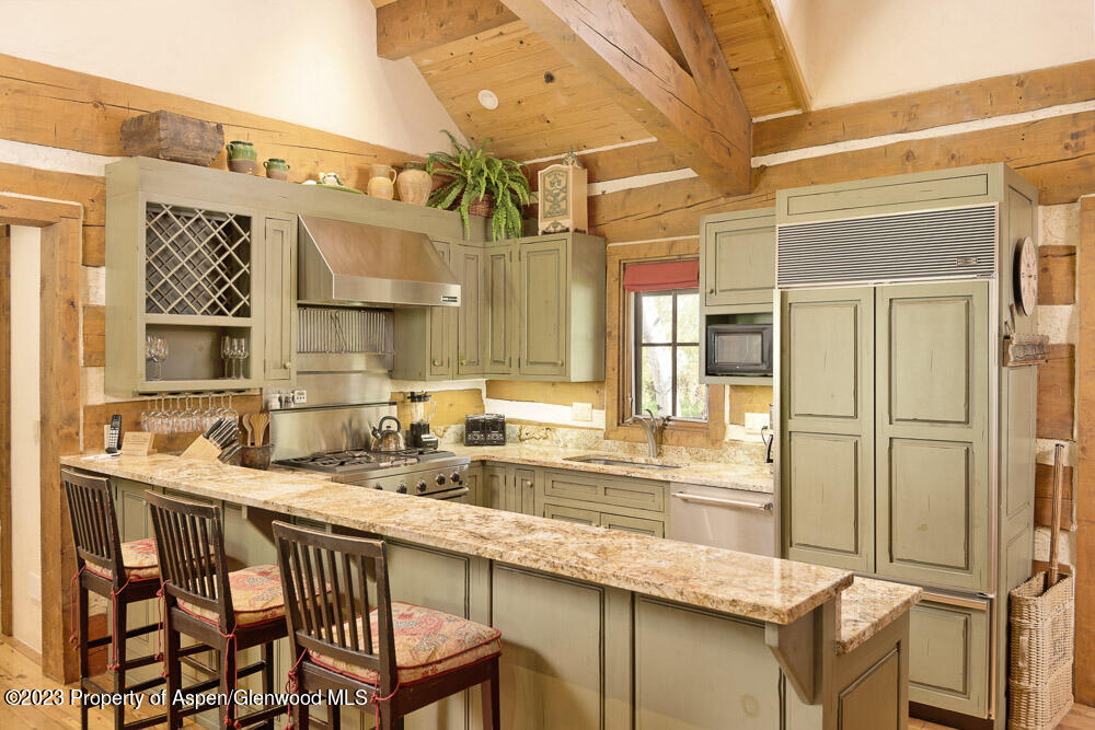 26 Altamira Ranch Road Basalt, CO 81621 - Photo 9 of 40 a kitchen with a table chairs refrigerator and cabinets