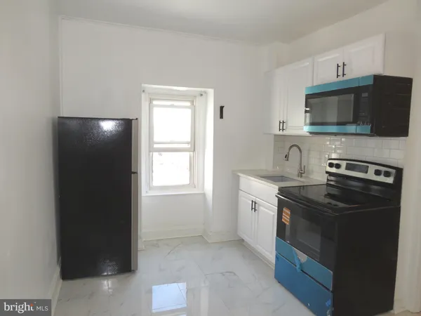 a kitchen with a sink and a stove top oven
