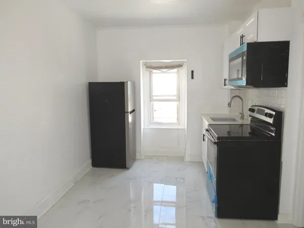 a room with a flat screen tv and refrigerator