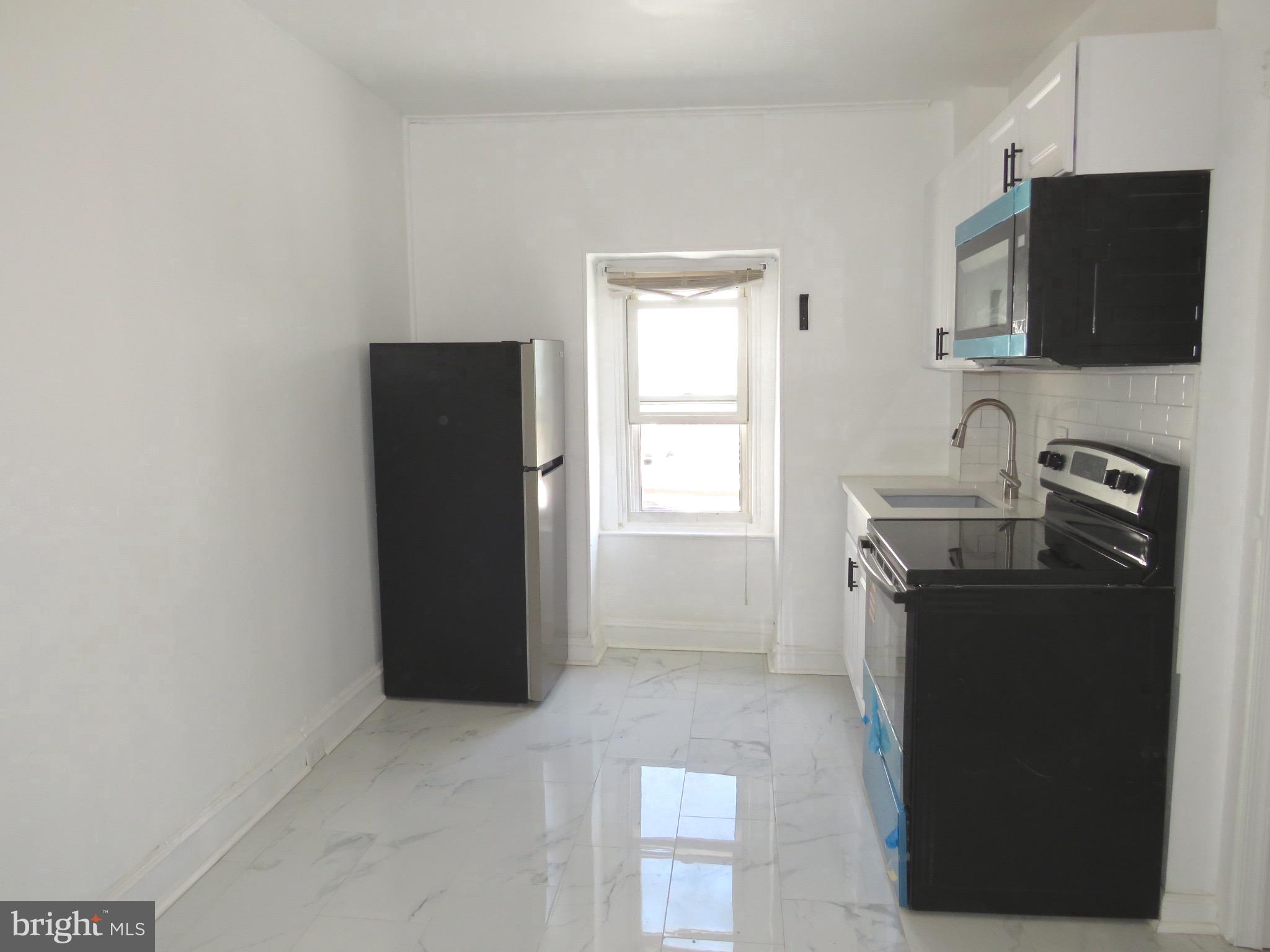 356 East Walnut Lane, Unit 3 Philadelphia, PA 19144 - Photo 5 of 18 a room with a flat screen tv and refrigerator