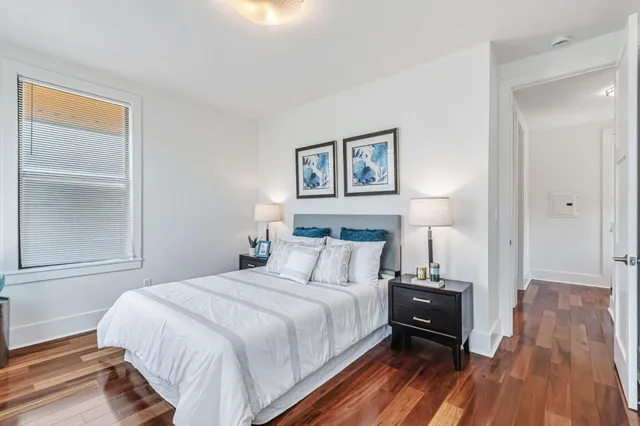 a bedroom with a bed and a wooden floor