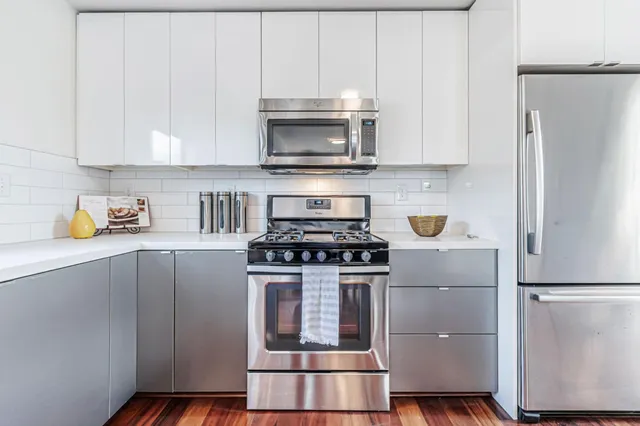 a kitchen with refrigerator a stove a microwave and cabinets