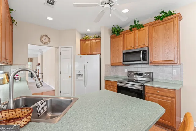 a kitchen with stainless steel appliances granite countertop a sink stove and refrigerator