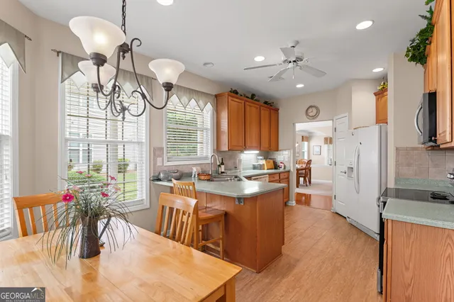 a view of a dining room and livingroom with furniture wooden floor a chandelier