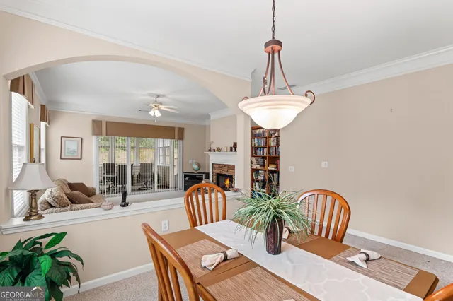 a dining room with furniture potted plants and wooden floor