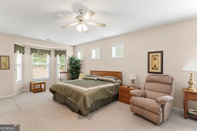 a bedroom with a bed a couch and potted plant