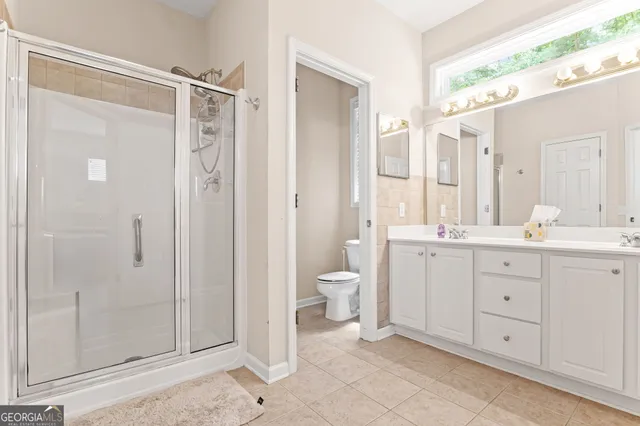 a bathroom with a double vanity sink toilet and shower