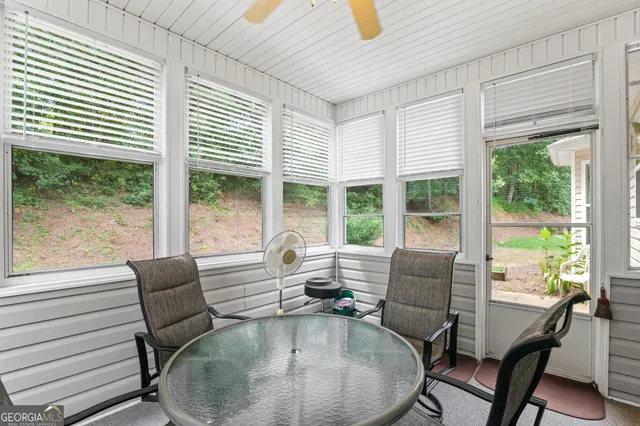 a dining room with furniture large windows and wooden floor