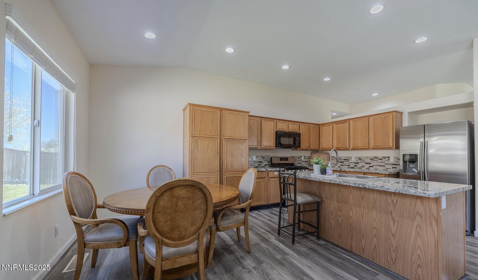 4080 Twin Falls Drive Reno, NV 89511 - Photo 5 of 16 a kitchen with granite countertop cabinets a dining table and stainless steel appliances