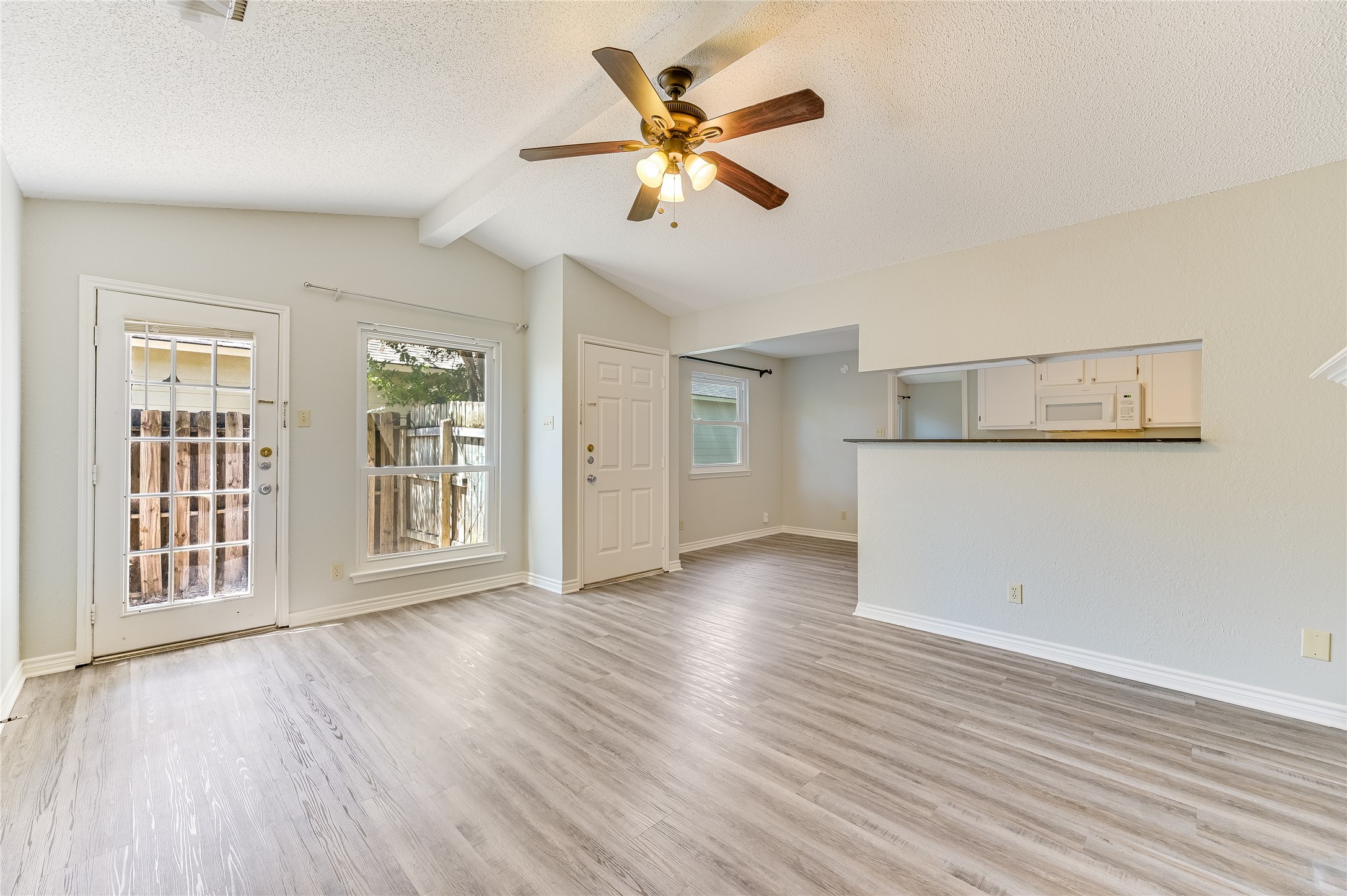 526 Cutty Trail, Unit B Lakeway, TX 78734 - Photo 3 of 10 Open-concept living area featuring wood-finish flooring, a vaulted ceiling, and a ceiling fan