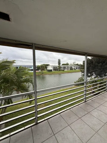 a view of a balcony with floor to ceiling windows with wooden floor