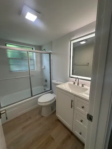 a bathroom with a toilet a sink and glass door