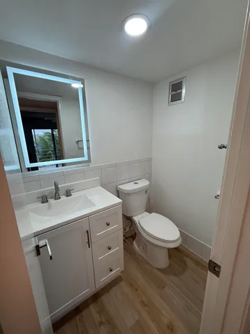 a bathroom with a toilet a sink and mirror