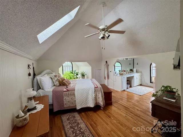 a bedroom with a bed wooden floor and ceiling fan