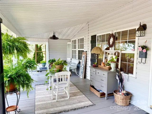 a view of a patio with a table chairs and a barbeque