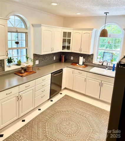 a kitchen with a sink window and cabinets