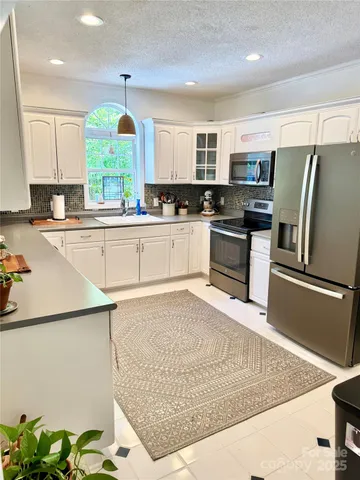 a large kitchen with stainless steel appliances granite countertop a sink stove and refrigerator