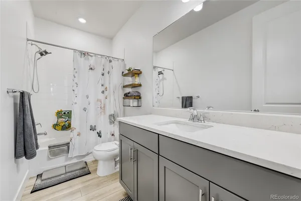 a bathroom with a granite countertop sink toilet and shower