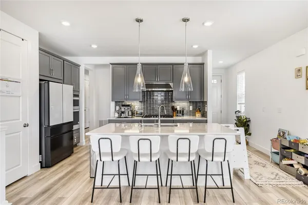 a kitchen with stainless steel appliances granite countertop a stove a refrigerator a oven a sink with a dining table and chairs