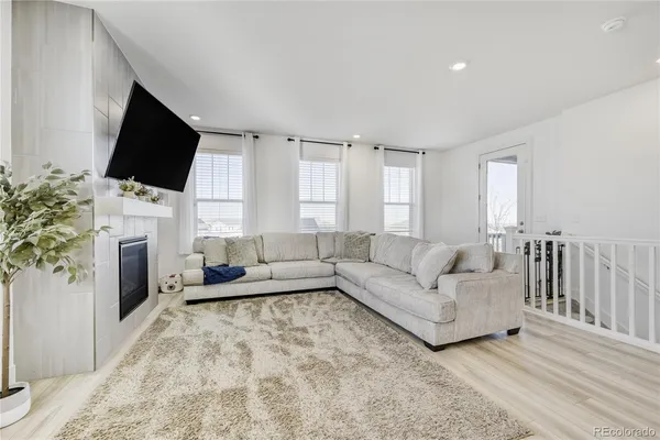 a living room with furniture a flat screen tv and a fireplace