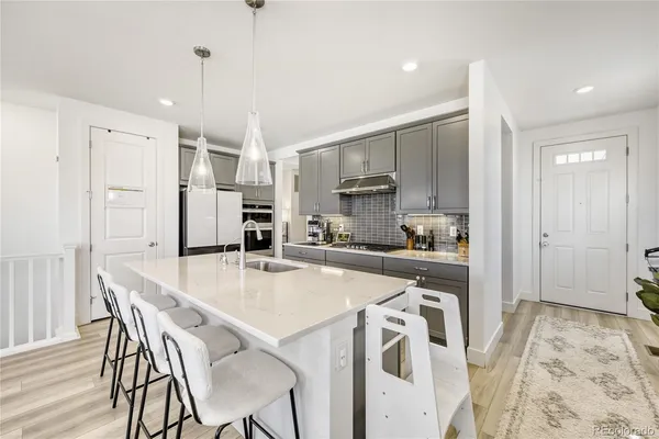 a kitchen with stainless steel appliances a stove a sink island and a refrigerator
