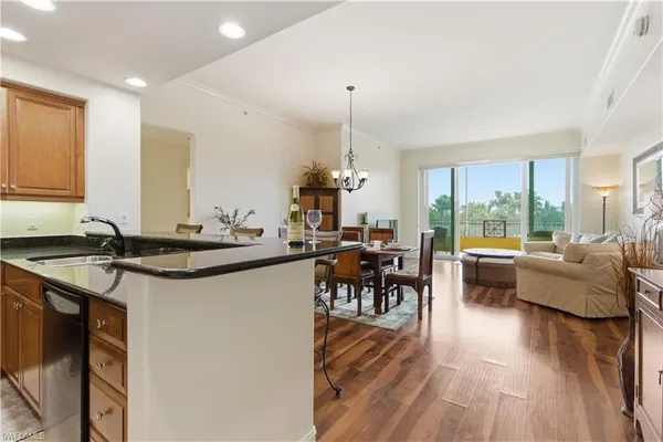 a kitchen with stainless steel appliances granite countertop a sink refrigerator and cabinets