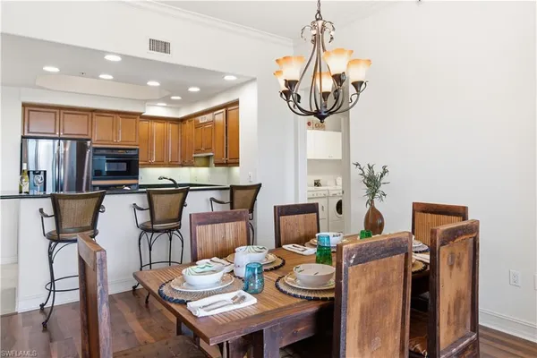 a view of a dining room with furniture a chandelier and wooden floor