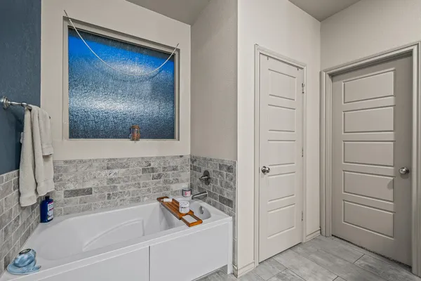a bathroom with a granite countertop sink a mirror and a bathtub
