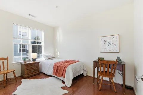 a bedroom with a bed and a bookshelf with wooden floor