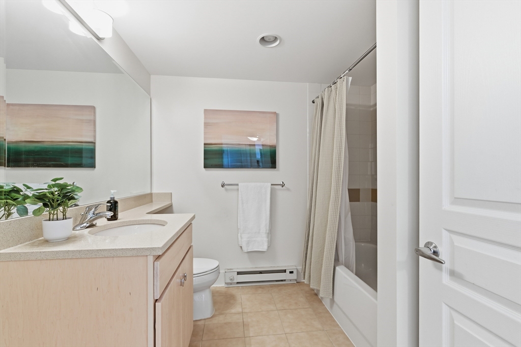 3 Repton Place, Unit 3204 Watertown, MA 02472 - Photo 15 of 18 a bathroom with a sink a mirror a vanity and a shower