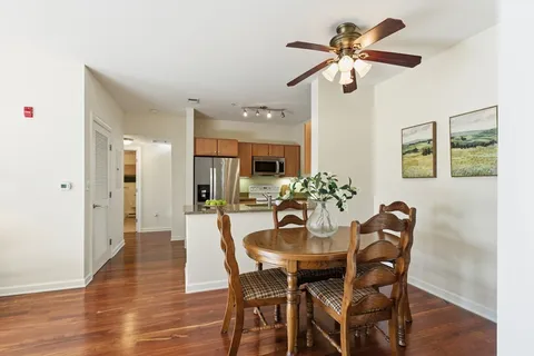 a view of a dining room with furniture and a chandelier fan