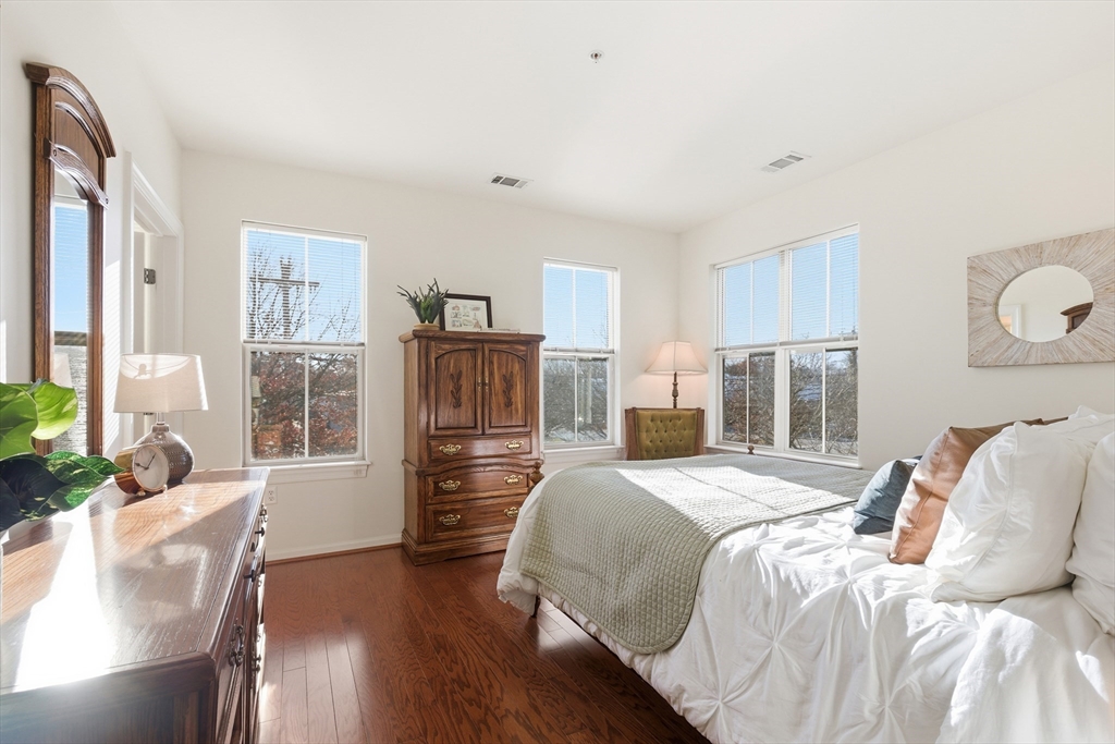 3 Repton Place, Unit 3204 Watertown, MA 02472 - Photo 8 of 18 a bedroom with a bed and wooden floor