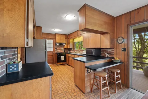 a kitchen with stainless steel appliances granite countertop a sink a stove and a refrigerator