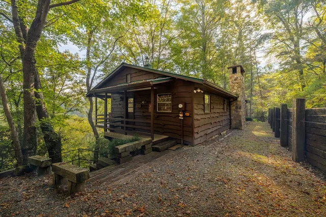 a view of a small house with a yard and furniture