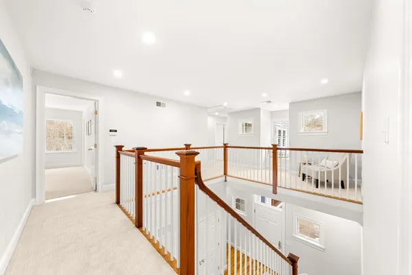 a view of staircase with lots of frames on wall and windows