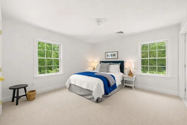 a bedroom with a bed chair and a window