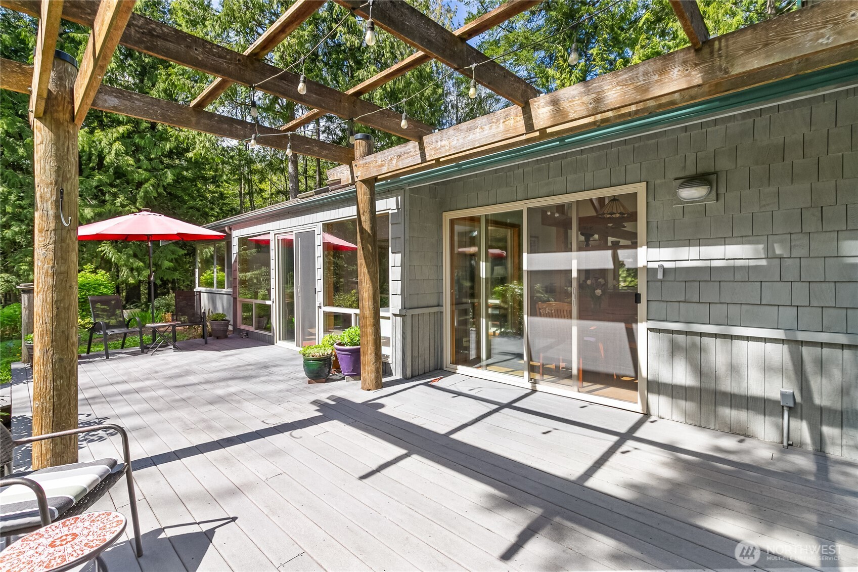2490 Goshen Road Bellingham, WA 98226 - Photo 31 of 40 a view of a patio with a table and chairs under an umbrella with a small yard