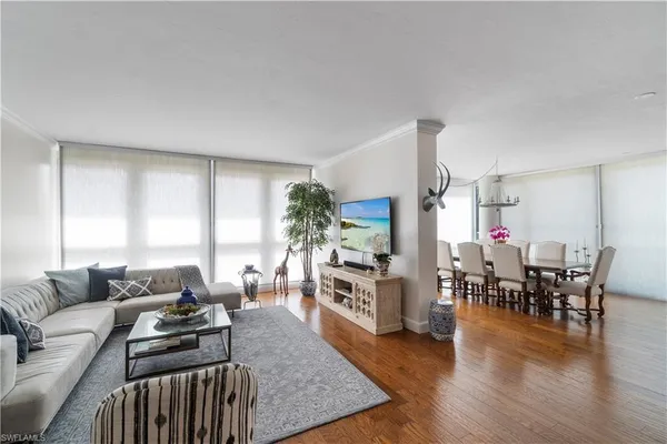 a living room with furniture dining table and a large window