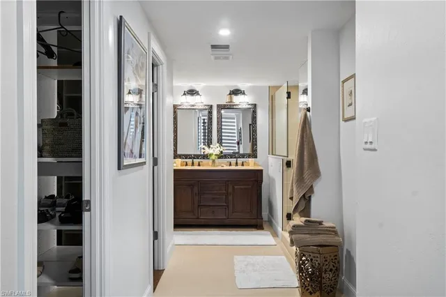 a bathroom with a double vanity sink mirror and shower