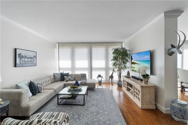a living room with furniture a large window with kitchen view