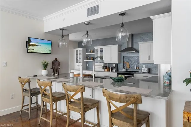 a kitchen with stainless steel appliances granite countertop a sink stove refrigerator and cabinets