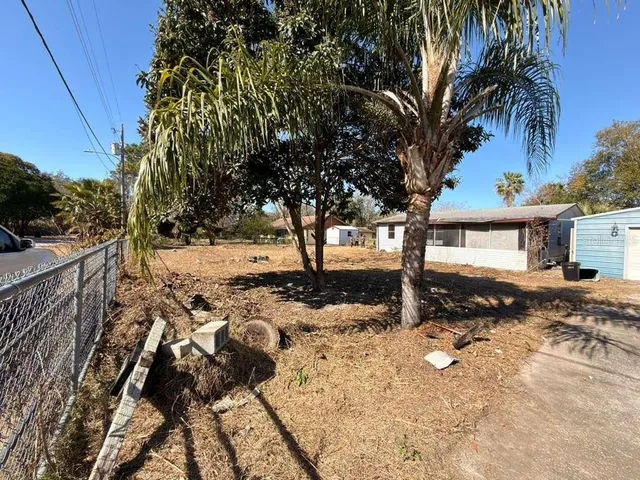 a view of a yard with wooden fence