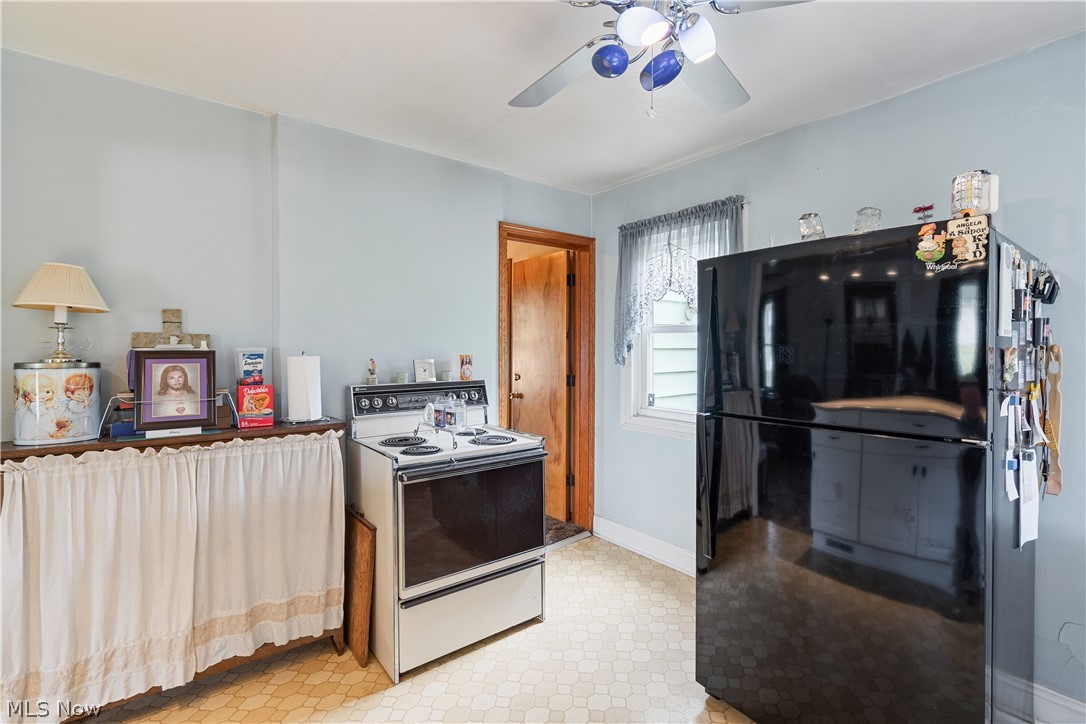 6324 Struthers Road Youngstown, OH 44514 - Photo 28 of 42 Kitchen area featuring light blue walls, a white ceiling fan with blue accents, and patterned tile-look flooring