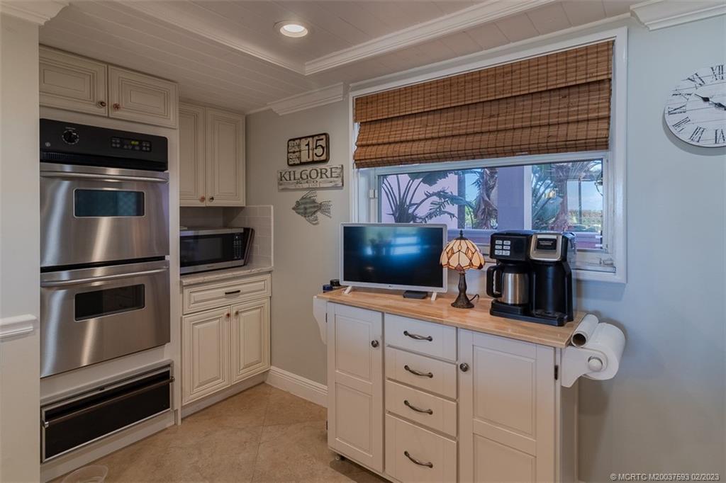 1701 Northeast Ocean Boulevard, Unit 103 Stuart, FL 34996 - Photo 12 of 46 a kitchen with white cabinets and stainless steel appliances