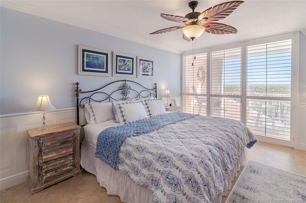 1701 Northeast Ocean Boulevard, Unit 103 Stuart, FL 34996 - Photo 18 of 46 a bedroom with a bed and a chandelier