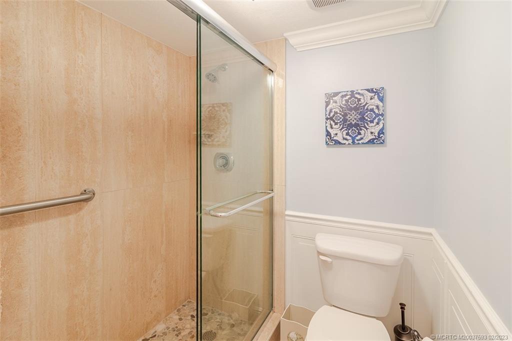 1701 Northeast Ocean Boulevard, Unit 103 Stuart, FL 34996 - Photo 21 of 46 a bathroom with a toilet and a shower