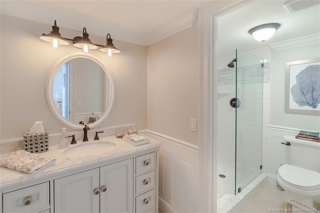 1701 Northeast Ocean Boulevard, Unit 103 Stuart, FL 34996 - Photo 26 of 46 a bathroom with a toilet a sink and mirror