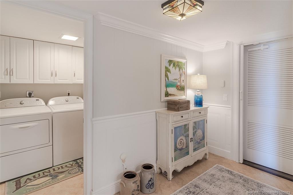 1701 Northeast Ocean Boulevard, Unit 103 Stuart, FL 34996 - Photo 27 of 46 a utility room with cabinets washer and dryer