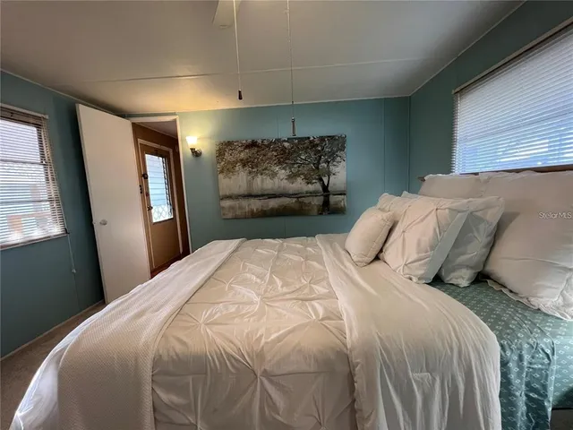 a bedroom with a bed chandelier and a window